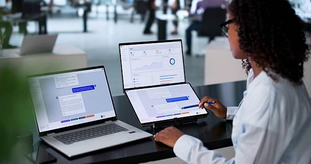 Woman using dual-screen laptop with AI chat